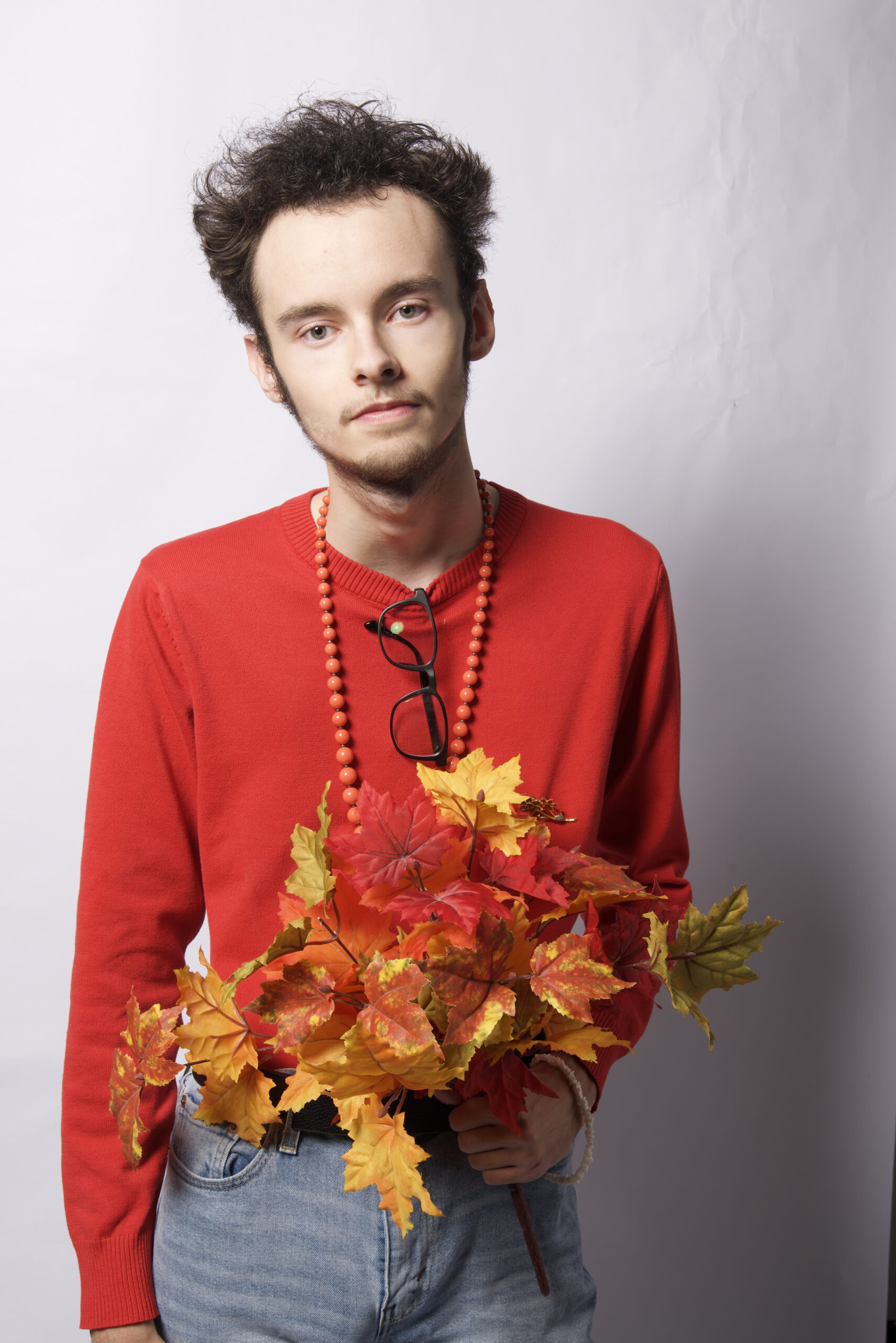An On Figure Shot of Nicholas wearing a red long sleeve shirt and blue jeans
